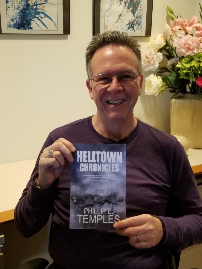 Phil Temples holding proof copy of Helltown Chronicles