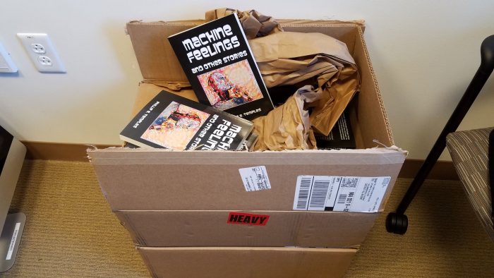 Box full of copies of Machine Feelings