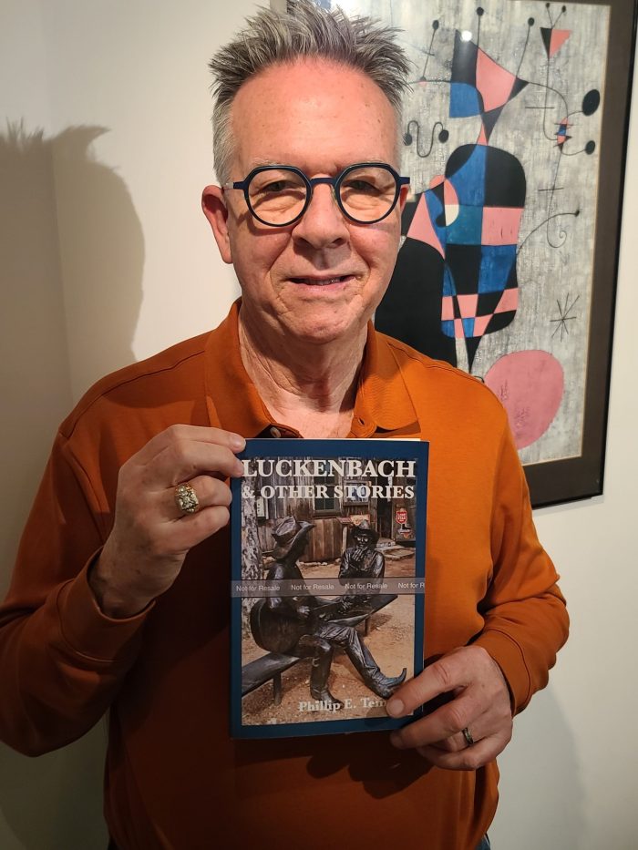 Temples posed with proof copy of "Luckenbach"